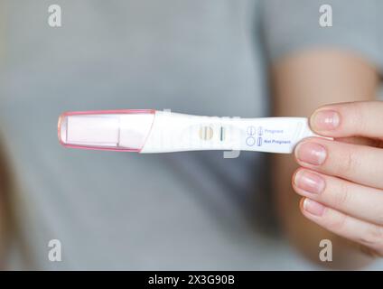 Nahaufnahme einer Frau mit positivem Schwangerschaftstest Stockfoto