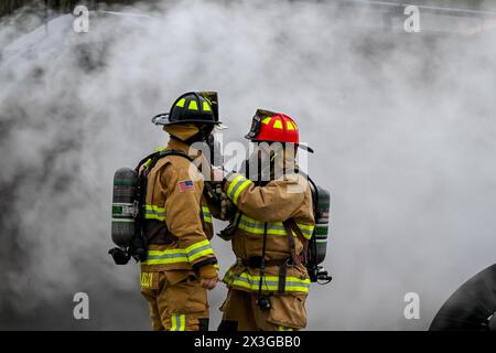 John West, der Feuerwehrkapitän der Youngstown Air Reserve Station, hilft dem Feuerwehrmann Mike Sanducci, seine Ausrüstung anzupassen, während er auf einen Flugzeugabsturz auf dem Feuerwehrübungsplatz während einer Übung in der Youngstown Air Reserve Station, Ohio, am 25. April 2024 reagiert. Der Schulungsbereich bietet Feuerwehrleuten der Feuerwehr der Anlage, anderer Verteidigungsministerien und umliegender Gemeinden die Möglichkeit, an lebenden Bränden auf dem Apparat zu trainieren, der die Konstruktion verschiedener Flugzeugtypen in der Gegend nachbildet. (Foto der U.S. Air Force von Eric M. White) Stockfoto