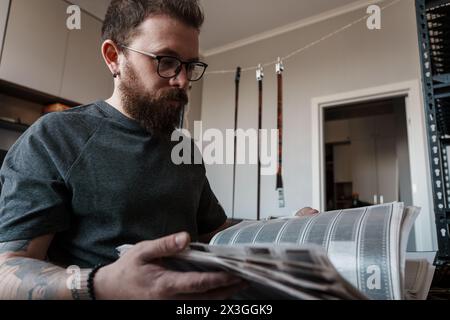 Fotograf untersucht Filmnegative in einem Kreativstudio Stockfoto