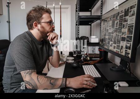 Professioneller Fotograf, der Fotos auf dem Computer überprüft Stockfoto