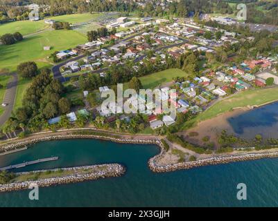 Luftaufnahme einer Wohnsiedlung entlang einer Küstenlinie und eines Wellenbrechers in der Batemans Bay in New South Wales, Australien Stockfoto