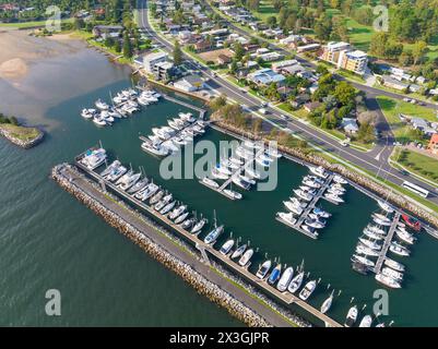 Aus der Vogelperspektive der Boote an einem Küstenhafen entlang einer befahrenen Straße in der Batemans Bay in New South Wales, Australien. Stockfoto