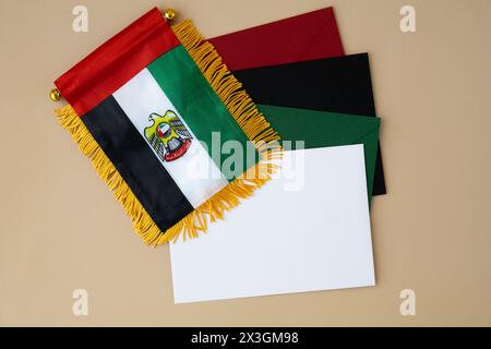 Bunte Umschläge Vorlage Beispiel National Symbol der VAE. Kleine Flagge der Vereinigten Arabischen Emirate mit Wanderfalke auf neutralem beigem Hintergrund. Kopieren Sie den Platz für Ihren Text. Das Konzept der Unabhängigkeit des Nationaltages Stockfoto