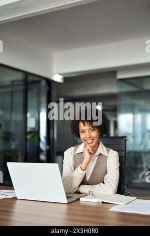 Professionelle glückliche afroamerikanische Geschäftsfrau im Büro, vertikales Porträt. Stockfoto