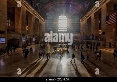 Sonnenstrahlen strahlen strahlen auf das Grand Central Terminal oder die Haupthalle des Bahnhofs, die die Menschen in den Schatten stellen. Erbaut im Beaux Arts-Stil in Midtown Manhattan, New York Stockfoto