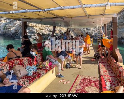 Khasab, Oman - 1. Januar 2024: Eine Gruppe von Touristen begeben sich auf eine aufregende Reise und erkunden die atemberaubenden Fjorde von Khasab mit dem Boot, umgeben von cryst Stockfoto