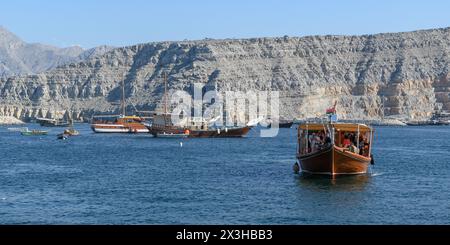 Khasab, Oman - 1. Januar 2024: Ein Panoramablick auf Touristen an Bord traditioneller omanischer Boote, bei der Erkundung der majestätischen Fjorde von Khasab, umgeben von Teppichen Stockfoto