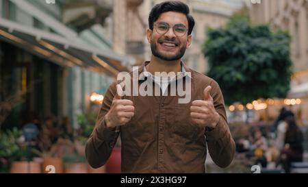 Glücklicher lächelnder enthusiastischer indischer arabischer männlicher Mann Mann Geschäftsmann mit Blick auf die Kamera positiver Gewinner freut sich über den Sieg, der Glück feiert Stockfoto