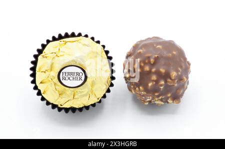 Ocala, FL 2-17-2024 italienische Haselnuss Premium Schokolade süß mit Crushed knusprige Waffel Ferrero Roche, gewickelt in goldgoldene Verpackung in dunklem Pap Stockfoto