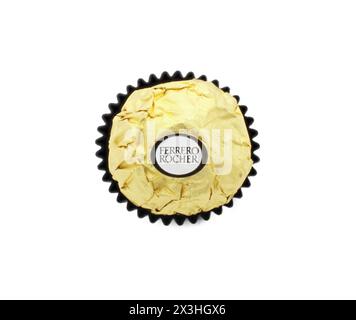 Ocala, FL 2-17-2024 italienische Haselnuss Premium Schokolade süß mit Crushed knusprige Waffel Ferrero Roche, gewickelt in goldgoldene Verpackung in dunklem Pap Stockfoto