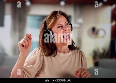 Lächelnd Ältere Senior Listening Musik Auf Kopfhörer Stockfoto