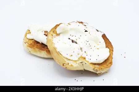 Ein köstlicher hausgemachter New york City Stil Mohn Sesam Bagel mit Frischkäse, beide Hälften bereit zu essen isoliert auf weißem Hintergrund Stockfoto