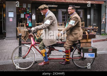 London, Großbritannien. April 2024. Ein Tandemfahrrad mit zwei Herren auf einer Mission zu fahren. Die Teilnehmer fahren durch den Exmouth Market. Der Tweed Run ist eine Fahrradtour durch die historischen Straßen Londons, wobei die Teilnehmer ihre besten Tweed- und stilvollen Fahrradbekleidung tragen müssen. Sie wird von Bourne & Hollingsworth organisiert und wurde 2008 mit nur einer kleinen Gruppe von Freunden gegründet, die rund 800 Radfahrer durch das Zentrum von London fahren. Copyright Credit: Imageplotter/Alamy Live News Stockfoto