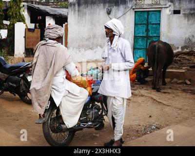 Rajasthan, Indien 02.05.2023. Der alte Rajasthani-Mann mit Turban. Zwei Indianer reden auf der Straße eines kleinen Dorfes in Rajasthan. Szene des gewöhnlichen Dagels Stockfoto