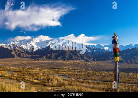 Panoramablick auf das Ladakh-Tal mit blauem Indus-Fluss in der Mitte und schneebedeckten Berggipfeln im Hintergrund. Stockfoto