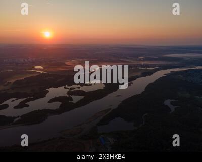 Farbenfroher Sonnenuntergang mit langen Flüssen und dickem Wald im Sommer Stockfoto