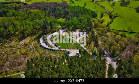 Blick aus der Vogelperspektive auf einen Parkplatz, umgeben von üppigem Grün und einem sich windenden Fluss in einer ländlichen Gegend. Stockfoto