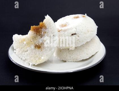 Gedämpfter Reiskuchen oder Bhapa Pitha ist ein traditionelles Gericht in Bangladesch. Winter-Reiskuchen auf schwarzem Hintergrund. Biss oder gebrochene Pitha. Zutaten sind Reis Stockfoto