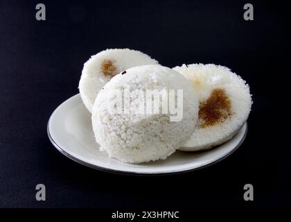 Gedämpfter Reiskuchen oder Bhapa Pitha ist ein traditionelles Gericht in Bangladesch. Winter-Reiskuchen auf schwarzem Hintergrund. Biss oder gebrochene Pitha. Zutaten sind Reis Stockfoto