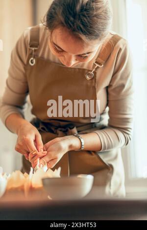 Sweet Finishing Touch: Eine Person, die Cupcakes mit Zuckerguss versehen, zeigt die Präzision und Liebe zum Detail beim Backen und Stockfoto
