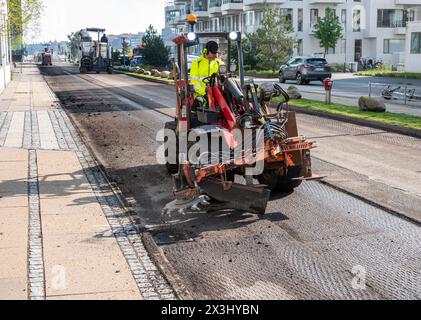 Asphaltfräs- und Schleifschaber bei Straßenreparaturen. Straßenerneuerung mit Maschinen. Kopenhagen, Dänemark - 27. April 2024. Stockfoto