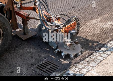 Asphaltfräs- und Schleifschaber bei Straßenreparaturen. Straßenerneuerung mit Maschinen. Stockfoto