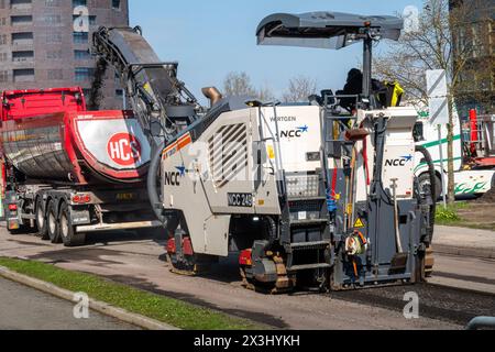 Asphaltfräs- und Schleifschaber bei Straßenreparaturen. Straßenerneuerung mit schweren Maschinen. Kopenhagen, Dänemark - 27. April 2024. Stockfoto