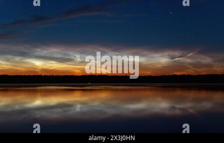 Wunderschöner Sonnenuntergang über dem See. Nachtwolken Stockfoto