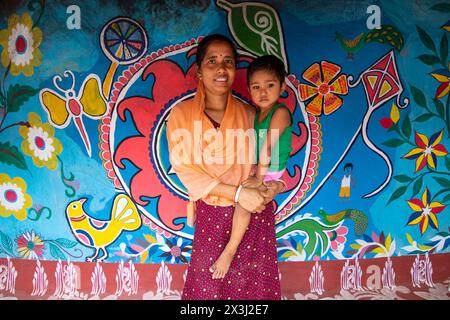 Chapainawabganj, Rajshahi, Bangladesch. April 2024. Fast alle Häuser in einem Dorf in Bangladeschs nordwestlichem Viertel Chapainawabganj sind mit der südasiatischen traditionellen Kunst namens „Alpona“ geschmückt. Die Kunst wird traditionell von Frauen praktiziert. Das Dorf ist im Land als „Alpona Gram“ (Kunstdorf) bekannt. Santals lebten schon sehr lange im Norden dieses Landes. Die Farben und Muster, die sie unter ihnen vorenthalten, und die Kultur, die sie haben, sind sehr unterschiedlich und sehr hell im Vergleich zu den vielen anderen ethnischen Menschen, die in diesem Land leben. Die lebendigste Stockfoto