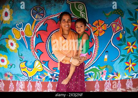 Chapainawabganj, Rajshahi, Bangladesch. April 2024. Fast alle Häuser in einem Dorf in Bangladeschs nordwestlichem Viertel Chapainawabganj sind mit der südasiatischen traditionellen Kunst namens „Alpona“ geschmückt. Die Kunst wird traditionell von Frauen praktiziert. Das Dorf ist im Land als „Alpona Gram“ (Kunstdorf) bekannt. Santals lebten schon sehr lange im Norden dieses Landes. Die Farben und Muster, die sie unter ihnen vorenthalten, und die Kultur, die sie haben, sind sehr unterschiedlich und sehr hell im Vergleich zu den vielen anderen ethnischen Menschen, die in diesem Land leben. Die lebendigste Stockfoto