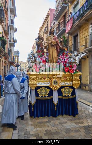 Tarragona, Spanien - 27. April 2024: Respektvolle Zuschauer säumen die Bürgersteige, einige halten den Moment mit ihren Kameras fest. Stockfoto