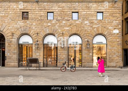 Florenz, Italien - 5. April 2024: Boutique CHANEL FLORENZ auf der Piazza della Signoria, Eingang mit Fenstern und Elektrofahrrad zu mieten vor dem Hotel auf Pflaster Stockfoto