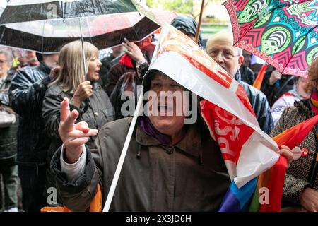 Eine Frau schützt ihren Kopf vor Regen mit einer Plastikfahne der spanischen Sozialistischen Arbeiterpartei PSOE während einer Kundgebung in der Ferraz-Straße. Tausende von Menschen haben sich vor dem Hauptquartier der spanischen Sozialistischen Arbeiterpartei PSOE versammelt, um Präsident Pedro Sanchez zu unterstützen, der sich einige Tage Zeit genommen hat, um über seine Zukunft an der Spitze der spanischen Regierung nachzudenken, nachdem seine Frau mit angeblichen Fragen in Verbindung gebracht wurde Korruption. Gleichzeitig fand im Gebäude eine Sitzung des Bundesausschusses der Partei statt. Stockfoto