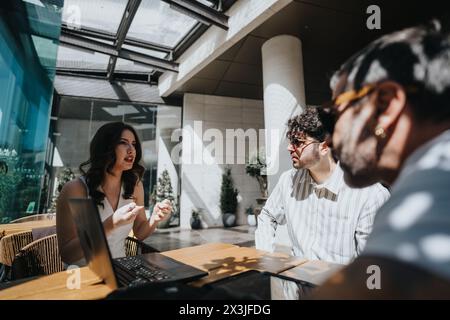 Unternehmerisches Team in einem Café, das Wachstumsstrategien und Statistiken diskutiert Stockfoto