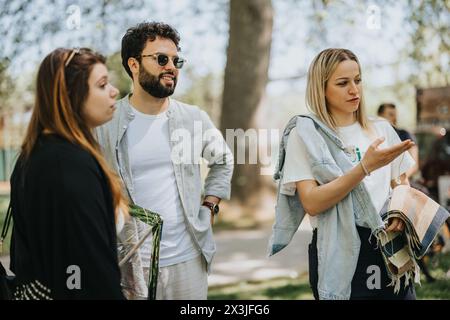 Multirassische Freunde, die sich in einem sonnigen Park unterhalten Stockfoto