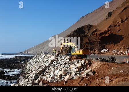 Ein Komatsu-Bagger, der an einem Projekt zur Verbesserung der Straßenzufahrt und der Parkmöglichkeiten für die Cuevas de Anzota/Anzota-Höhlen in der Nähe von Arica, Chile, arbeitet Stockfoto