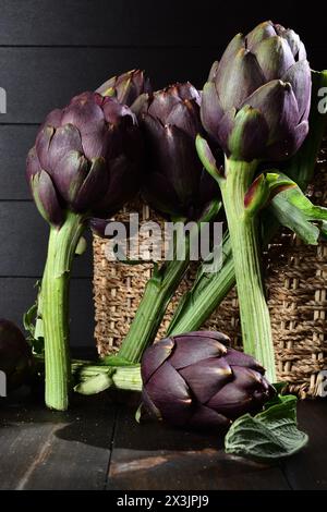 Bio-Artischocken auf einem Holzbrett. Stockfoto