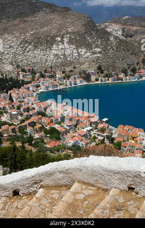 Klippenstufen (Vordergrund), Kastellorizo Harbour (Hintergrund) Kastellorizo (Megisti) Island, Dodekanes Group, Griechenland Stockfoto