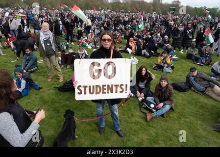 London, Großbritannien. April 2024. Eine Frau hält ein Plakat mit der Aufschrift "gehe zu Studenten!" - Ein Verweis auf streng polizeiliche Studentenproteste in den USA - während sich eine große Menge palästinensischer Unterstützer in Hyde Park versammeln, die einen Waffenstillstand und ein Ende der Unterstützung Großbritanniens und der USA für Israels Belagerung, Bombardierung und Invasion von Gaza nach einem Angriff von Hamas-Militanten fordern. Der Protest war der dreizehnte nationale marsch gegen Israels Krieg gegen Gaza, der im Oktober 2023 begann und vom Holocaust-Gelehrten Raz Segal als „Lehrbuchfall des Völkermords“ beschrieben wurde. Quelle: Ron Fassbender/Alamy Live News Stockfoto