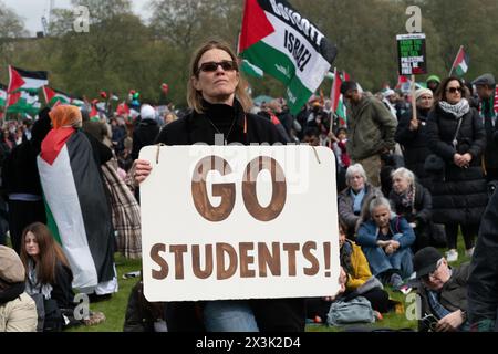 London, Großbritannien. April 2024. Eine Frau hält ein Plakat mit der Aufschrift "gehe zu Studenten!" - Ein Verweis auf streng polizeiliche Studentenproteste in den USA - während sich eine große Menge palästinensischer Unterstützer in Hyde Park versammeln, die einen Waffenstillstand und ein Ende der Unterstützung Großbritanniens und der USA für Israels Belagerung, Bombardierung und Invasion von Gaza nach einem Angriff von Hamas-Militanten fordern. Der Protest war der dreizehnte nationale marsch gegen Israels Krieg gegen Gaza, der im Oktober 2023 begann und vom Holocaust-Gelehrten Raz Segal als „Lehrbuchfall des Völkermords“ beschrieben wurde. Quelle: Ron Fassbender/Alamy Live News Stockfoto