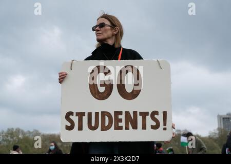 London, Großbritannien. April 2024. Eine Frau hält ein Plakat mit der Aufschrift "gehe zu Studenten!" - Ein Verweis auf streng polizeiliche Studentenproteste in den USA - während sich eine große Menge palästinensischer Unterstützer in Hyde Park versammeln, die einen Waffenstillstand und ein Ende der Unterstützung Großbritanniens und der USA für Israels Belagerung, Bombardierung und Invasion von Gaza nach einem Angriff von Hamas-Militanten fordern. Der Protest war der dreizehnte nationale marsch gegen Israels Krieg gegen Gaza, der im Oktober 2023 begann und vom Holocaust-Gelehrten Raz Segal als „Lehrbuchfall des Völkermords“ beschrieben wurde. Quelle: Ron Fassbender/Alamy Live News Stockfoto