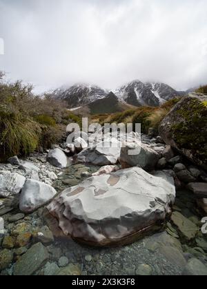 Erkunden Sie den atemberaubenden Hooker Valley Track mit schneebedeckten Bergen in Neuseeland, wo die Schönheit der Natur keine Grenzen kennt Stockfoto