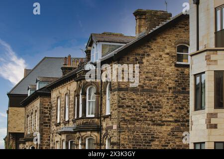 Historische Steingebäude mit komplexen architektonischen Details unter einem klaren blauen Himmel. Stockfoto