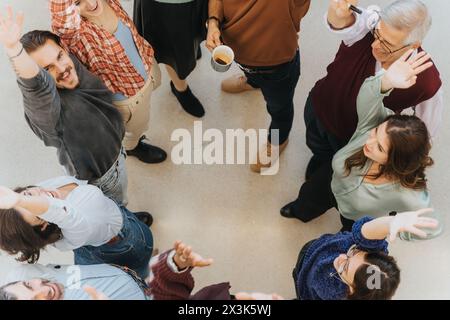 Generationenübergreifende Unternehmensgruppe von Menschen, die sich in einem Kreis von oben zusammenschließen. Stockfoto