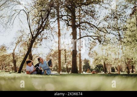 Ein junges Schulpaar sitzt zusammen im Park mit Büchern, die studieren Stockfoto