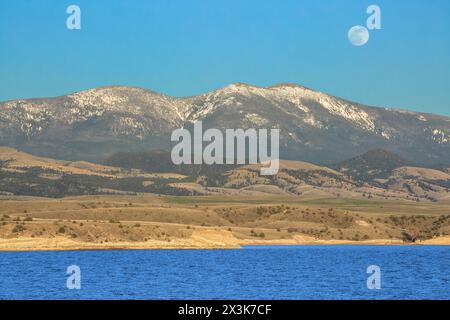 Der Vollmond steigt über den Glatzen in den Bergen des großen Gürtels und dem Fährsee in der Schlucht nahe townsend, montana Stockfoto