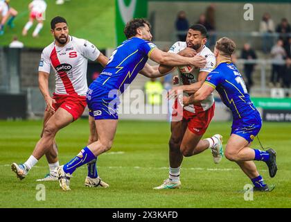 Salford, Manchester, Großbritannien. April 2024. Superliga Rugby: Salford Red Devils gegen Warrington Wolves im Salford Community Stadium. KALLUM WATKINS wird von BEN CURRIE und LEON HAYES angegriffen. James Giblin/Alamy Live News. Stockfoto