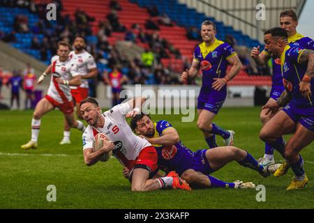 Salford, Manchester, Großbritannien. April 2024. Superliga Rugby: Salford Red Devils gegen Warrington Wolves im Salford Community Stadium. RYAN BRIERLEY wird kurz vor der Linie von TOBY KING angegriffen. James Giblin/Alamy Live News. Stockfoto