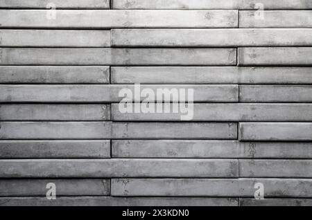 Vorderansicht einer Wand aus grauen Betonschiefern. Abstrakter, hochauflösender Texturhintergrund in Schwarzweiß, Kopierraum. Stockfoto