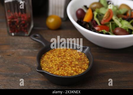 Leckere Essigsauce (Vinaigrette) auf Holztisch, Nahaufnahme Stockfoto